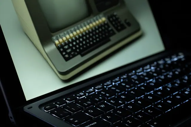 A vintage computer is reflected on a modern laptop screen, showcasing technological evolution. Office suites comparison: a side-by-side buyer guide